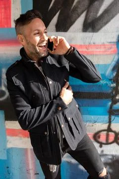 A young bearded man using the cell phone in the city Stock Photos