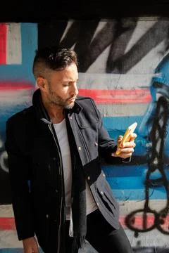 A young bearded man using the cell phone in the city Stock Photos