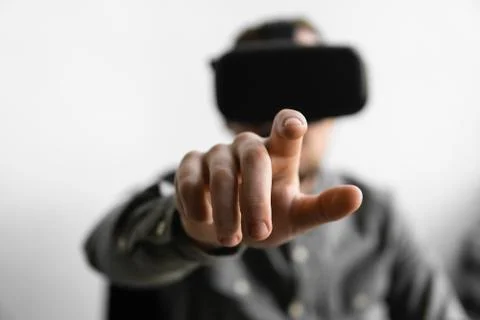 Young bearded man with virtual reality glasses trying to touch something or tap Stock Photos