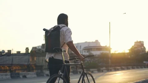 Young bearded man walking down the street with his bike slow motion Stock-Footage 79237800