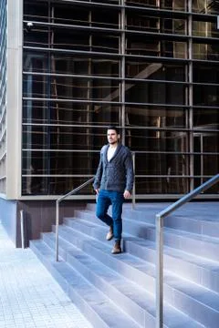 Young bearded man walking down the stairs of an office building Fotos de archivo
