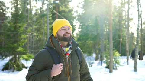 Young bearded man is walking through the winter forest Stock Footage 103990733