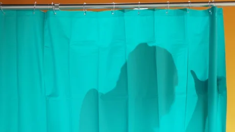 Young bearded man wearing cap washing himself in the shower looking scared of Stock Footage 125819685