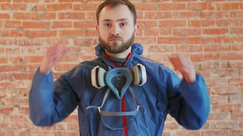 Young bearded man wearing protective workwear and mask, respirator Stock Footage 112960467