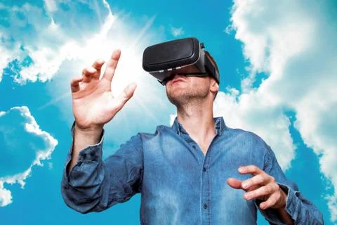 Young bearded man wearing virtual reality glasses in modern interior design c Stock Photos