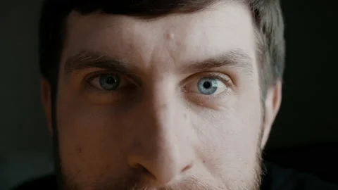 Young bearded man's blue iris eyes macro shot. Man is looking at the camera and Stock Footage 136473233