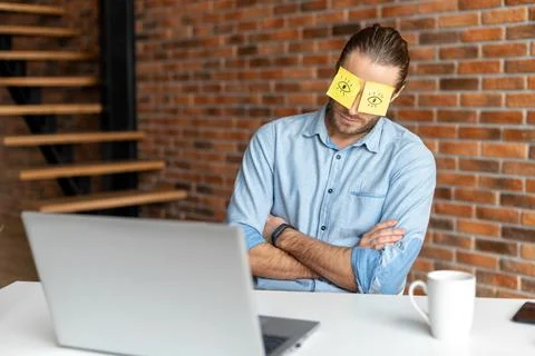 Young bearded office worker napping at work Foto stock