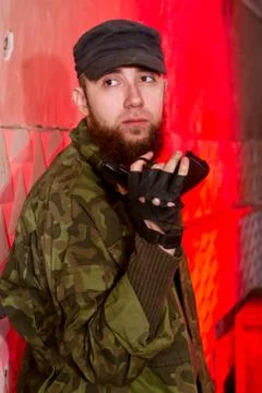 Young bearded terrorist with a gun in the stroma of a dilapidated shelter Stock Photos