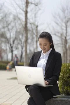 Young beauties use computers to work outdoors Stock Photos