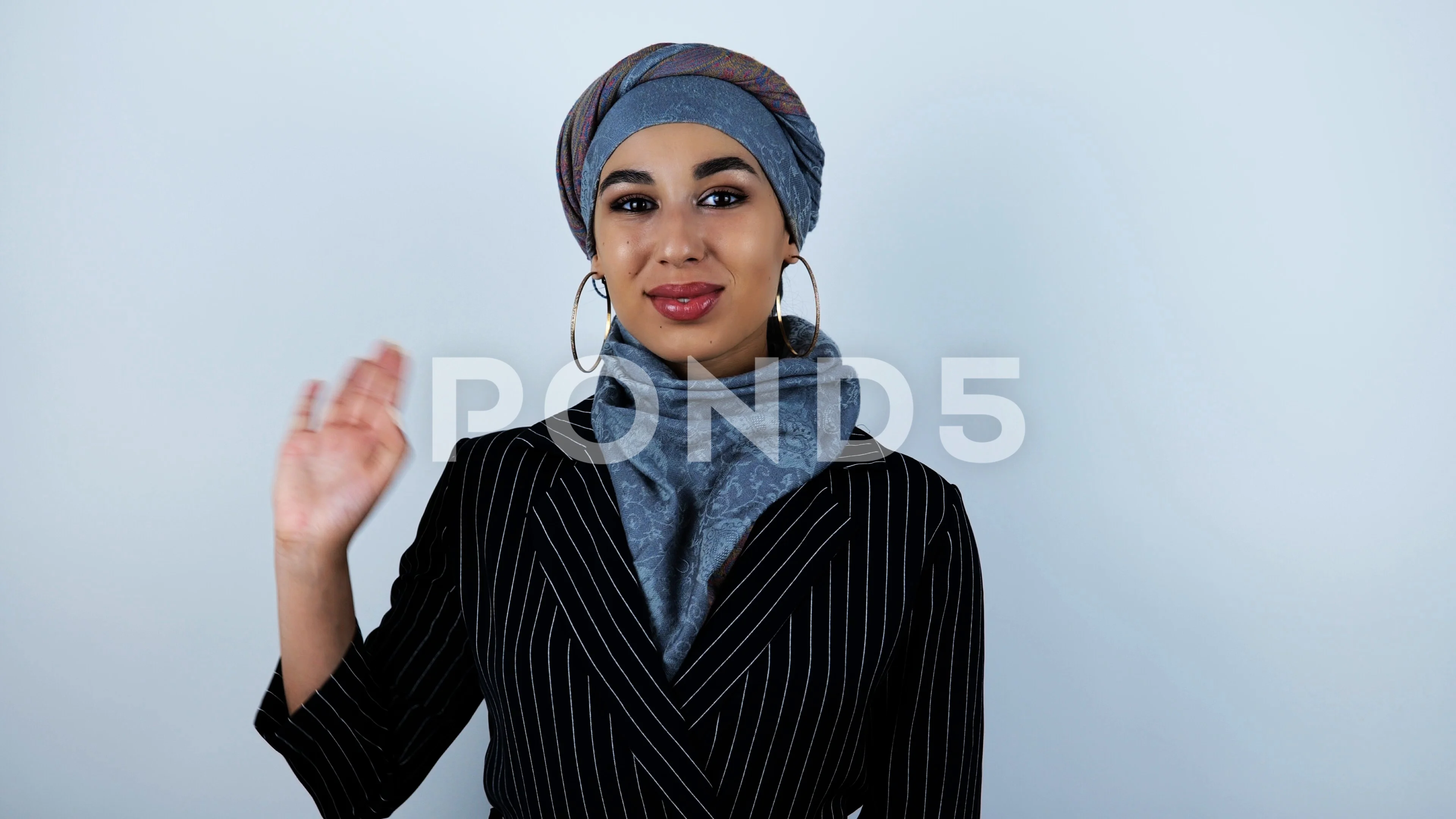 young beautiful arabic woman waving her hand and smiling on isolated white