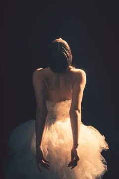 Young beautiful ballet dancer is posing in studio, view back. Stock Photos