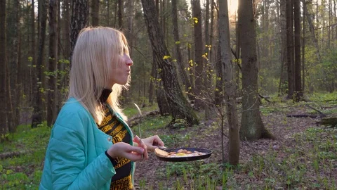 Young beautiful blonde eats on a picnic in the forest. She is a tourist. She has Stock Footage 129967016