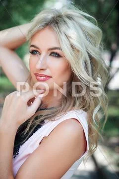 Young beautiful blonde girl in a park Stock Photos