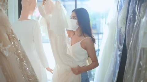 Young beautiful bride choosing a wedding outfit at wedding studio Stock Footage 147065952