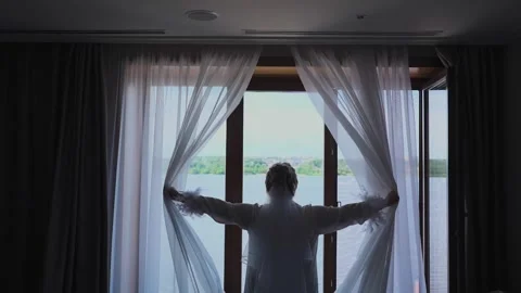 A young beautiful bride opens the curtains Stock Footage 327982447
