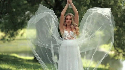 Young beautiful bride posing in the park in summer day. Wedding day. Stock Footage 95463500
