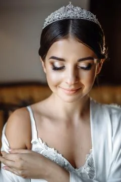Young beautiful bride posing in a robe by the window Foto stock