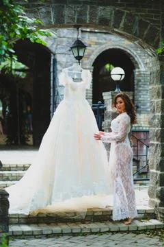 Young beautiful bride preparing to try on her luxury bridal dress Stock Photos