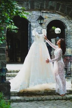 Young beautiful bride preparing to try on her luxury bridal dress Stock Photos