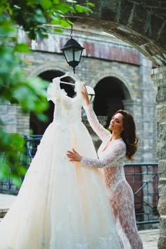 Young beautiful bride preparing to try on her luxury bridal dress Stock Photos