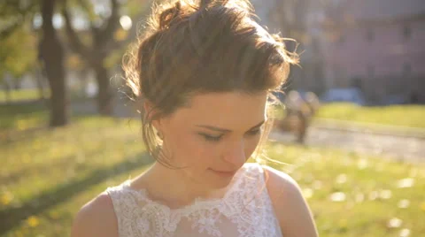 Young beautiful bride standing in the park  and straightens hair shot in slow Stock Footage 57457349