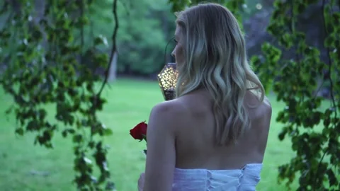 Young Beautiful Bride Walking In Park With Lantern and Rose, Turning to Camera Stock Footage 158521376