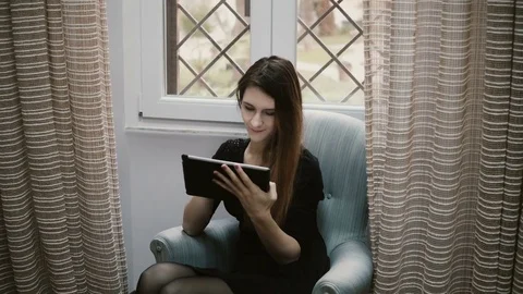 Young beautiful brunette girl surfing the Internet and using tablet computer for Stock Footage