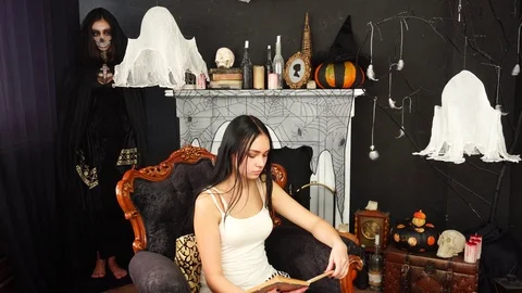 Young beautiful brunette reader dying as creepy violent woman in Death Reaper Stock Footage 95879107