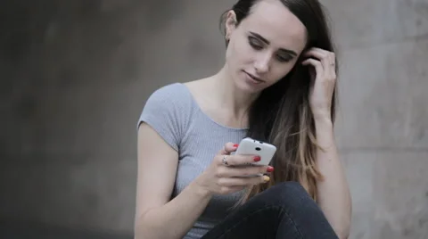 Young beautiful brunette typing a message on a smartphone Stock Footage 63911427