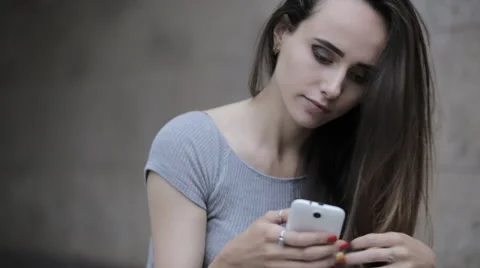 Young beautiful brunette typing a message on a smartphone Video stock 63911429
