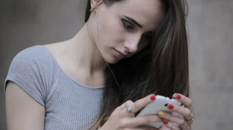Young beautiful brunette typing a message on a smartphone Stock Footage 63911435