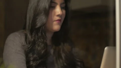 Young beautiful brunette using her laptop late at night Stock Footage 142665360