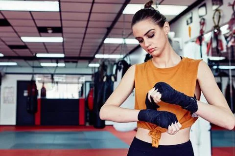 Young Beautiful Caucasian Woman Wraps Her Hands To Prepare to Box Stock Photos