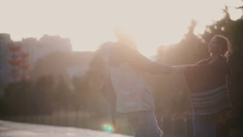 Young beautiful couple having fun in the rain. Happy man and woman turning Stock Footage 77582699