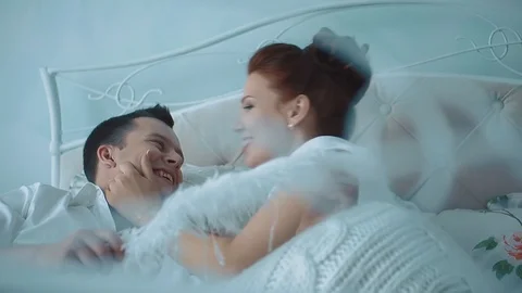 Young beautiful couple having fun in bed, she pinching him on the cheek Stock Footage 105091158