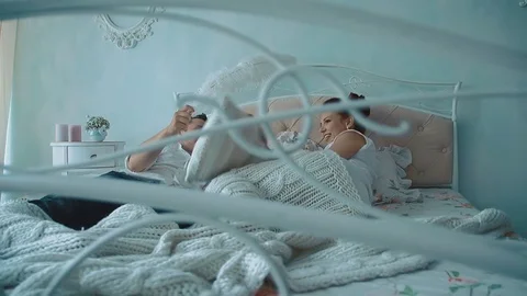 Young beautiful couple having fun in bed, they fight by cushions, laughing Stock-Footage 105091345