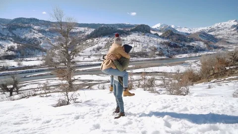Young beautiful couple having fun on a snowy hill on a sunny day. Stock Footage 124307863