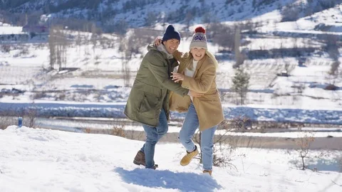 Young beautiful couple having fun on a snowy hill. winter holiday concept. Stock Footage 124904807