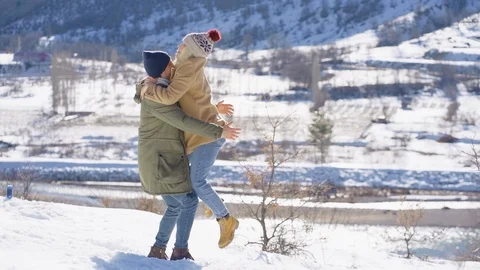 Young beautiful couple having fun on a snowy hill on a sunny day. Stock Footage 125052159
