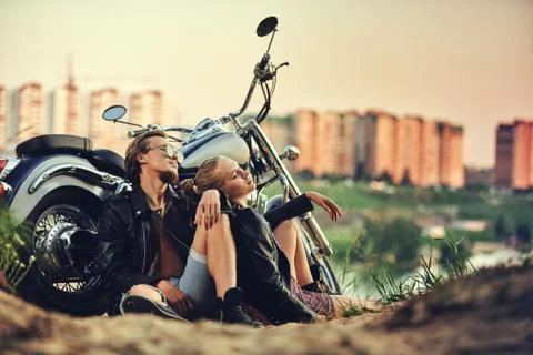 Young beautiful couple hipsters in stylish clothing for a retro motorcycle on Stock Photos