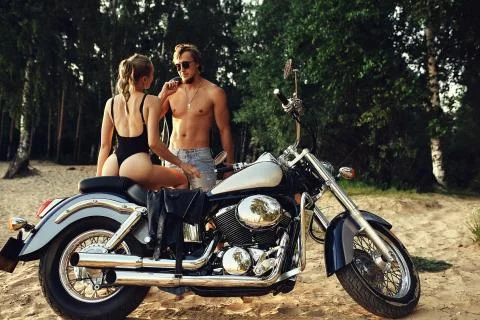 Young beautiful couple hipsters in stylish clothing for a retro motorcycle on Stock Photos