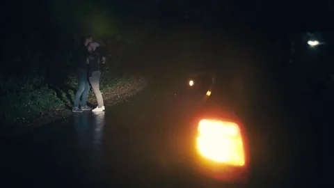 Young beautiful couple hugging and kissing on the roadside at night Stock Footage 83618170