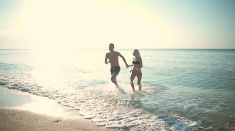 Young beautiful couple smiling, going out of sea. Slow motion. Stock Footage 68187877