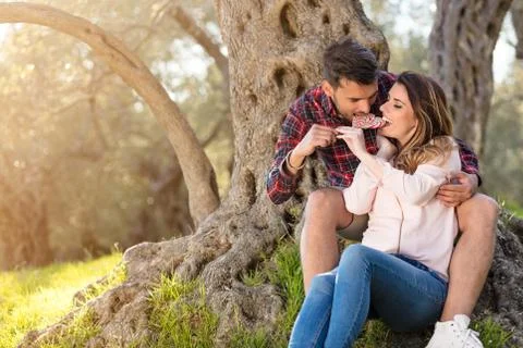 Young beautiful couple under tree in beautiful nature. Фото