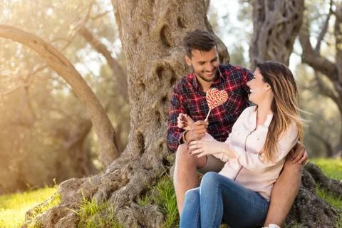 Young beautiful couple under tree in beautiful nature. Stock Photos