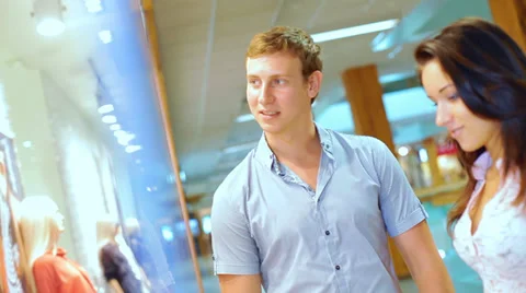 Young beautiful couple walking in the store and view items in shop windows Stock Footage 28293099