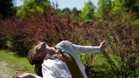 Young beautiful dancer with long brown hair dancing in nature Video stock 155583513