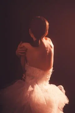 Young beautiful dancer posing in studio on dark background. Stock Photos