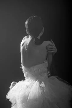 Young beautiful dancer posing in studio on dark background. Stock Photos
