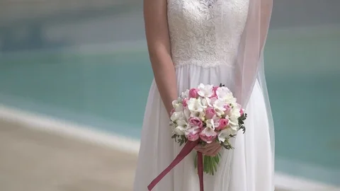 Young beautiful dark-haired bride veil on with bouquet smiling  Stock Footage 94675801